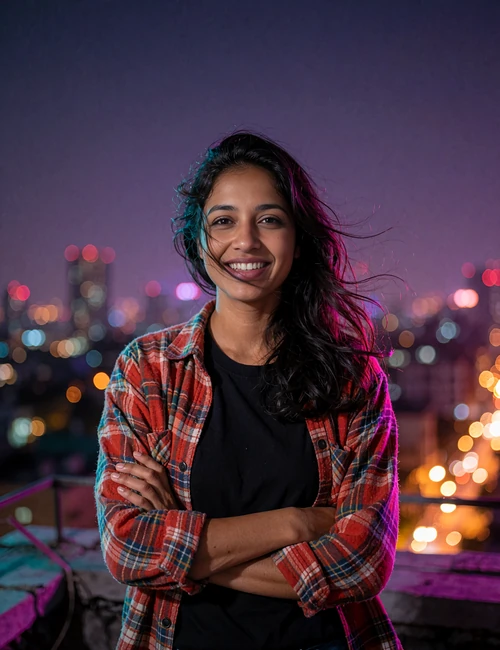 Woman in a red flannel shirt smiling on a rooftop at dusk, relaxed casual portrait